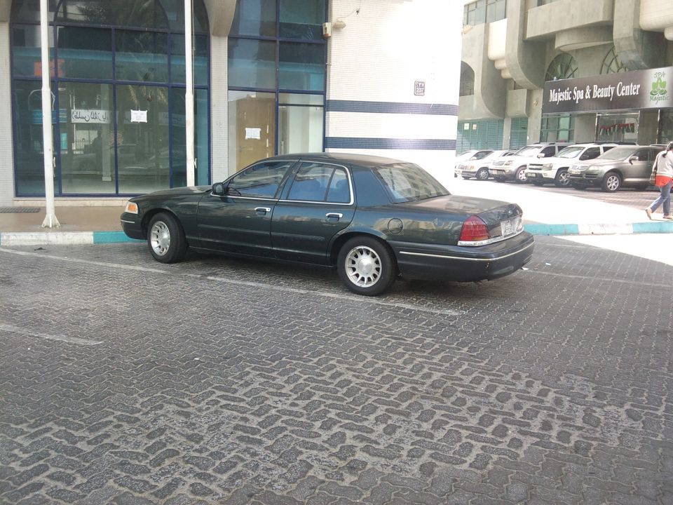 Dark green 1998 Ford Crown Victoria parked curbside