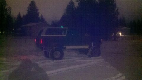 1978 Ford Mustang II - Lifted pickup truck with camper shell in a snowy outdoor setting.
