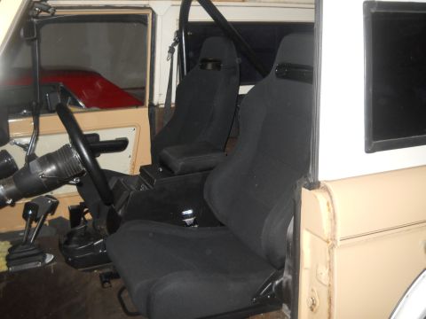 1976 Ford Bronco - The interior of a 1976 Ford Bronco is visible, aftermarket bucket seats and a roll bar.