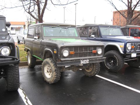 1994 Ford Bronco - Several Ford Broncos are parked in a lot on a cloudy day.