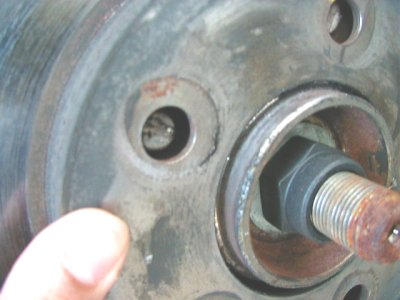 1997 Ford Taurus - A close-up view of a vehicle's wheel hub assembly, showing a socket on a bolt and some rust.