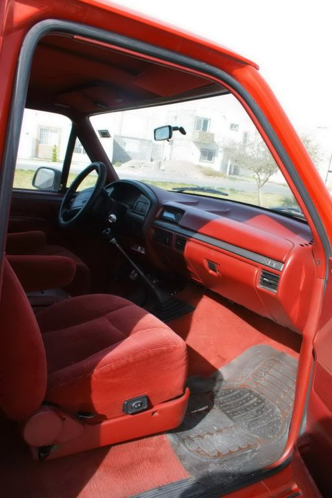 1995 Ford Bronco - The interior of a 1995 Ford Bronco features red upholstery and dashboard accents.