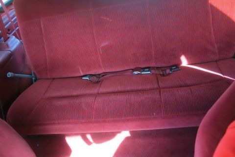 1995 Ford Bronco - Interior view of a red corduroy rear seat with seatbelts.