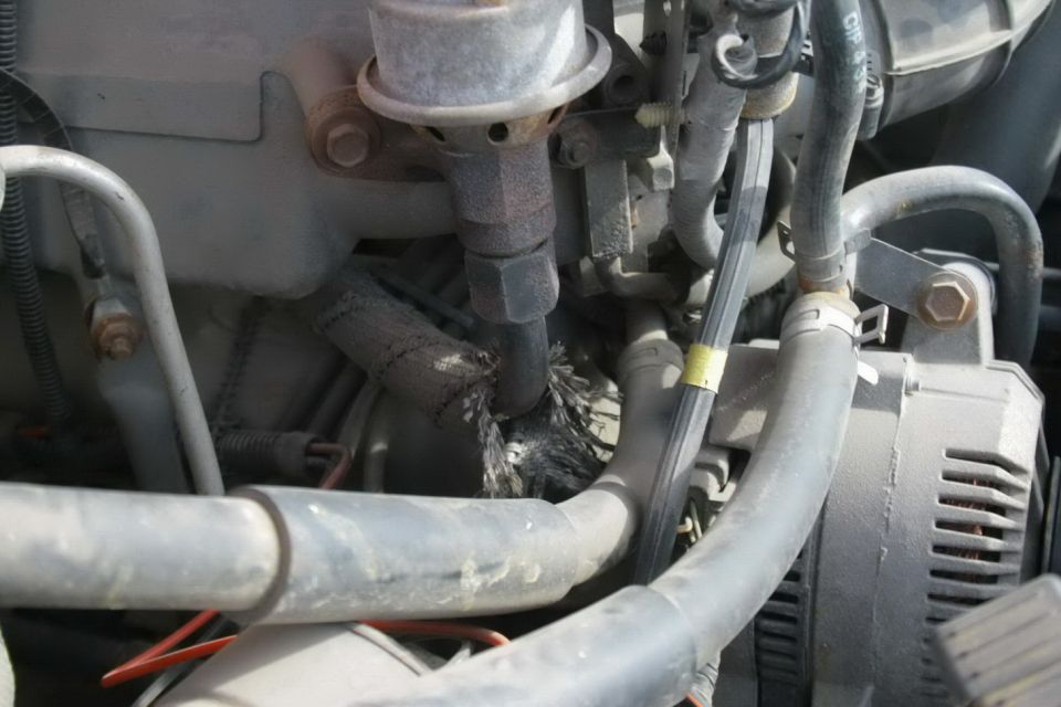 close-up of engine bay with hoses and alternator