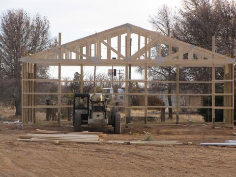 1995 Ford Bronco - A construction site shows a wooden building frame under construction, with two vehicles and lumber in the foreground.