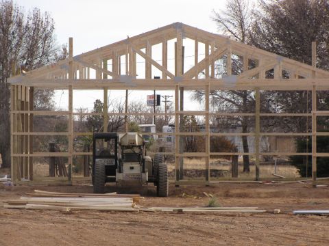 1995 Ford Bronco - Construction site shows an unfinished building frame with heavy machinery and lumber.