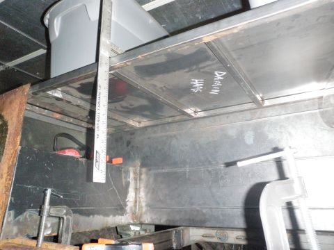 1961 International Scout 800 - A close-up view of metal shelving inside a structure, marked with names and measured with a ruler.