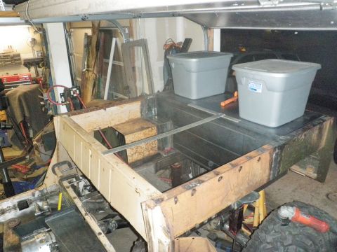 1961 International Scout 800 - This appears to be a vehicle frame and bed undergoing restoration or modification in a workshop.