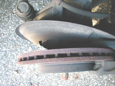 1997 Ford Taurus - Close-up view of a rusty brake rotor and associated suspension parts, with a SuperMotors watermark at the bottom.