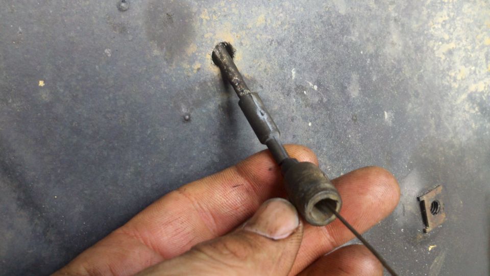Hand holding cable release mechanism with Supermotors logo visible