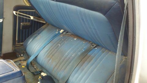 1978 Ford Bronco - The interior of a 1978 Ford Bronco shows worn blue rear seats and seatbelts.