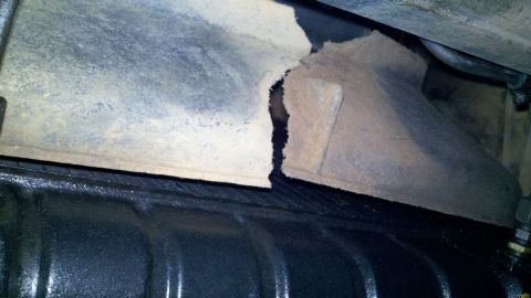 1978 Ford Bronco - Close-up of a damaged metal bracket, likely from a vehicle's undercarriage.