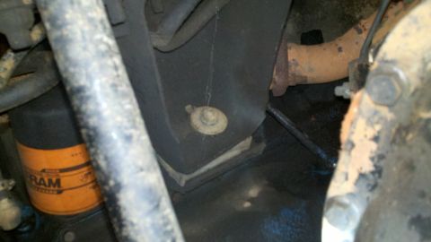 1978 Ford Bronco - The engine bay shows an oil filter and part of the exhaust system, with some fluid leakage visible on the ground.