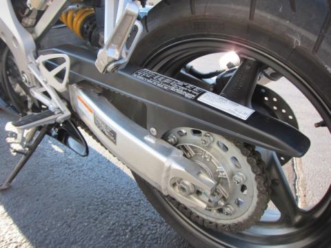 1999 Mercury Grand Marquis - The rear section of a motorcycle is visible, including the drive chain, sprocket, and suspension components.