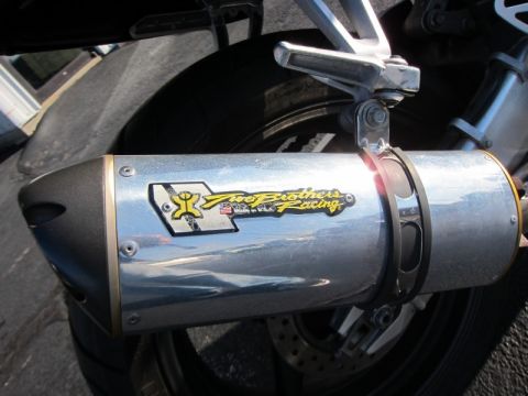 1999 Mercury Grand Marquis - Close-up of a motorcycle's exhaust pipe the Two Brothers Racing logo and a portion of the rear tire and brake disc.