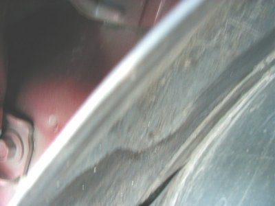 1997 Ford Taurus - A close-up view of a vehicle's wheel well liner, showing some wear and tear.