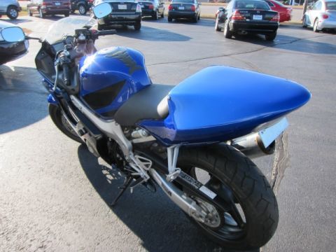 1999 Mercury Grand Marquis - A blue sport motorcycle is parked in a lot with other cars in the background.