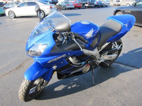 1999 Mercury Grand Marquis - A blue Honda CBR motorcycle is parked outdoors, with a watermark for Supermotors.net visible.