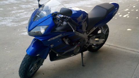 1999 Mercury Grand Marquis - A blue Honda CBR motorcycle is shown from the front three-quarter angle.