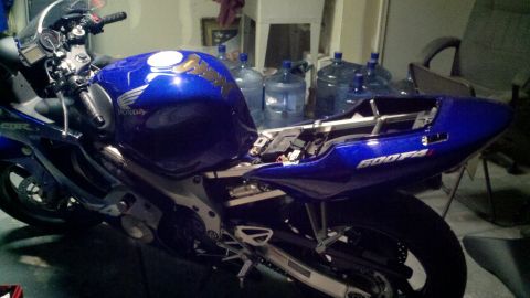 1999 Mercury Grand Marquis - A blue Honda CBR 600F4i motorcycle is shown in a side view, with some of its body panels removed.