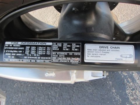 1999 Mercury Grand Marquis - Labels on a motorcycle detail tire information and drive chain maintenance instructions.