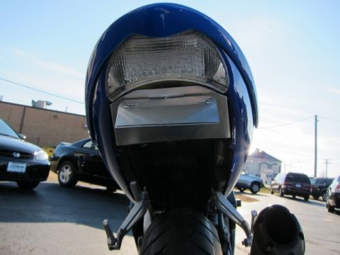 1999 Mercury Grand Marquis - Rear view of a motorcycle's tail light and license plate bracket, with cars visible in the background.