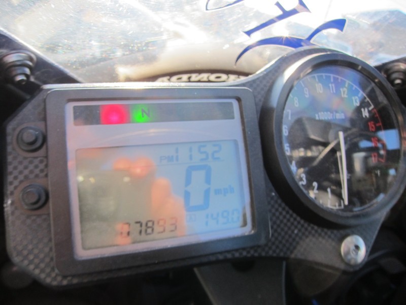 Motorcycle dashboard with digital display showing speed, odometer, and tachometer