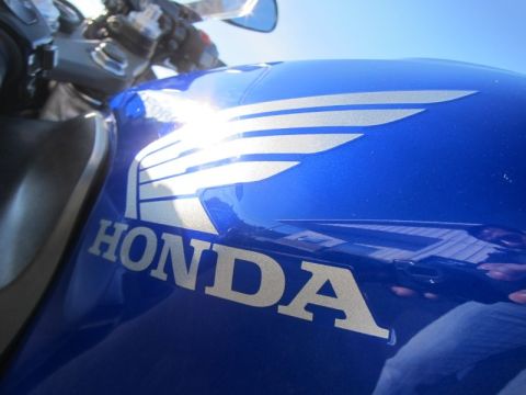 1999 Mercury Grand Marquis - Close-up of a blue Honda motorcycle fuel tank with its distinctive wing logo and brand name.