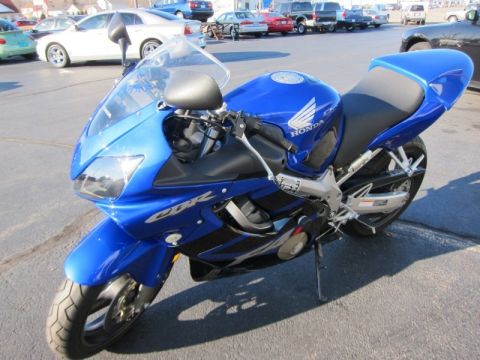 1999 Mercury Grand Marquis - A blue Honda CBR motorcycle is shown from the front-right angle in a parking lot.