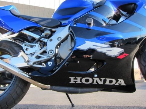 1999 Mercury Grand Marquis - A blue and black Honda motorcycle is shown from the side, with visible F4 and Honda branding.