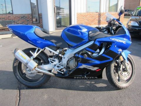1999 Mercury Grand Marquis - A blue and black Honda CBR motorcycle is parked outside a building.