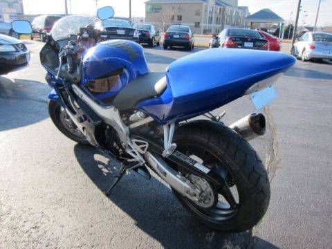 1999 Mercury Grand Marquis - A blue sportbike motorcycle is parked outdoors, showing its rear profile and exhaust.