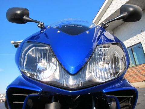 1999 Mercury Grand Marquis - This blue motorcycle has a prominent front fairing and dual headlights, with a Honda logo on the windscreen.