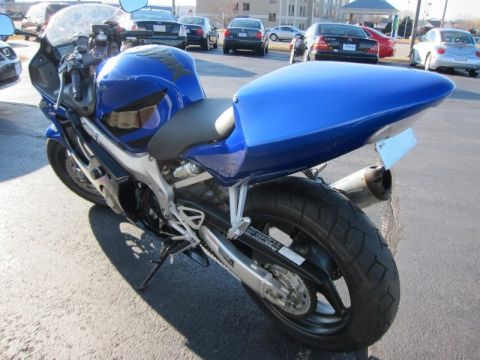 1999 Mercury Grand Marquis - A blue sport motorcycle is parked in a lot with other vehicles visible in the background.