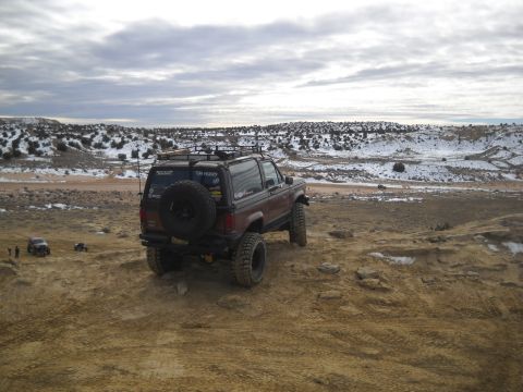 1992 Ford Explorer - This modified SUV, possibly a Ford Bronco II, is seen off-road with a spare tire mounted on the tailgate and a roof rack.