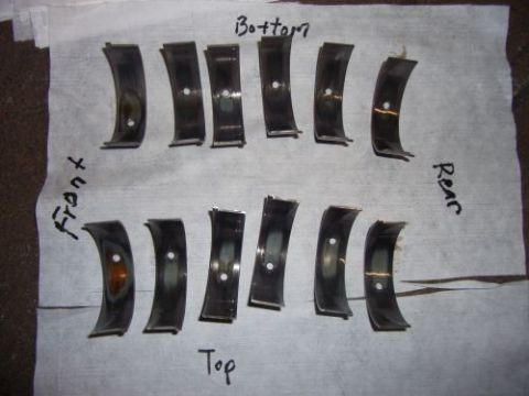 1991 Ford Taurus - Engine bearing shells are arranged and labeled on a paper surface, indicating their orientation.