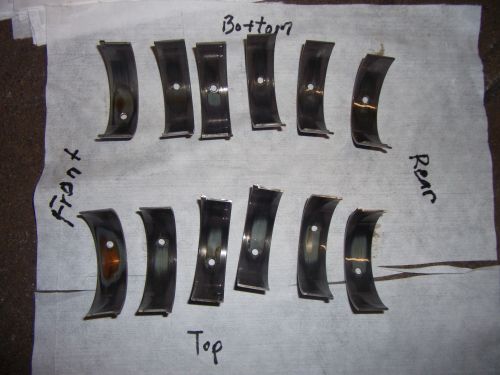 Engine bearing shells laid out on paper, labeled 'Front', 'Top', 'Bottom', and 'Rear'