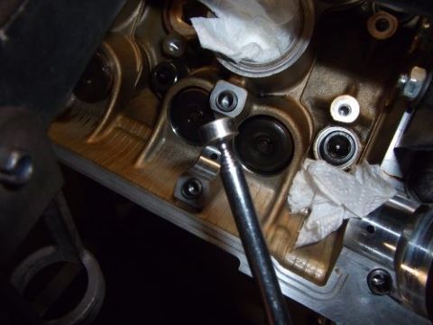 1991 Ford Taurus - Engine cylinder head work in progress, showing valves and a tool being used.