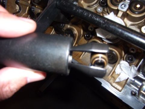 1991 Ford Taurus - A valve spring compressor tool is used on engine components. The registry claims this is a 1991 Ford Taurus, but the image does not confirm…