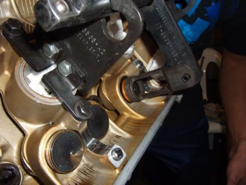 1991 Ford Taurus - Close-up of an engine valve spring compressor tool being used on engine components.