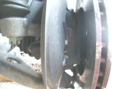 1997 Ford Taurus - Close-up of a car's brake rotor and suspension components, showing signs of wear and rust.