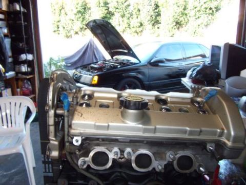 1991 Ford Taurus - Engine swap in progress on a 1991 Ford Taurus, with the car's hood open in the background.