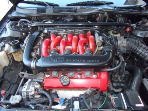 1991 Ford Taurus - Close-up view of a SHO 24 valve DOHC engine, red valve covers and a black intake manifold.