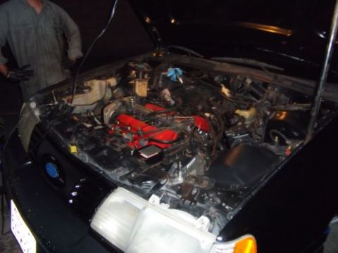 1991 Ford Taurus - Engine bay of a 1991 Ford Taurus, showing the red intake manifold.