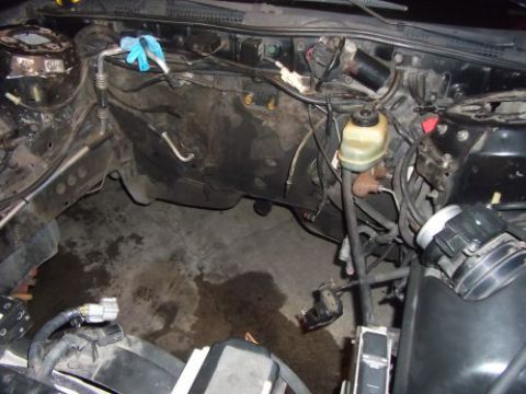 1991 Ford Taurus - The engine bay of a vehicle is shown, with various components and hoses visible, suggesting a state of disassembly or repair.