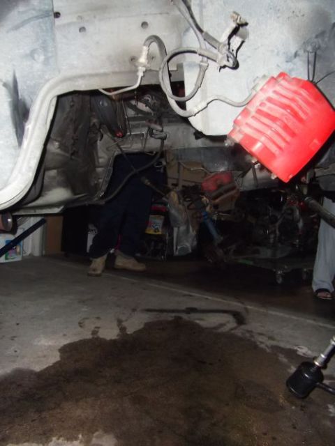 1991 Ford Taurus - Mechanics working on an engine assembly in a garage setting.