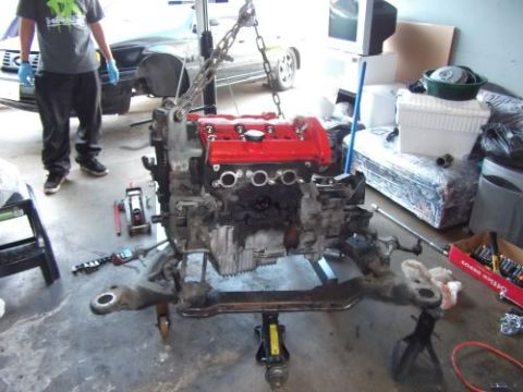 1991 Ford Taurus - Engine assembly being worked on in a garage setting with tools and other items visible.