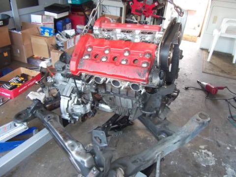 1991 Ford Taurus - Engine assembly, likely for an engine swap, is suspended and partially disassembled.