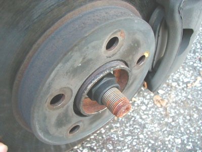 1997 Ford Taurus - Close-up of a rusty car wheel hub and brake rotor assembly.