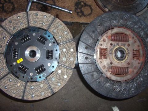 1991 Ford Taurus - Comparison of a new clutch disc and a used pressure plate, showing the 'ENGINE SIDE' marking on the latter.